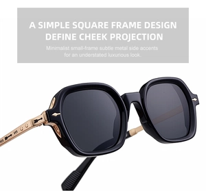 Close-up of square black sunglasses with golden metal temples and arrow relief detail