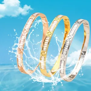 Drei stapelbare Titanstahl-Armreifen in Gold, Roségold und Silber mit Kleeblatt