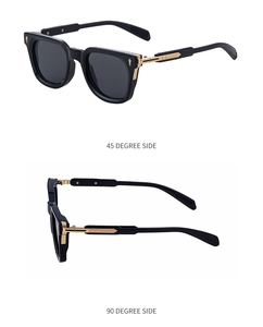 Detail view of square black sunglasses with golden metal accents on the side temples