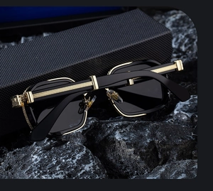 Detailed view of square black sunglasses with golden metal hinges and textured temples