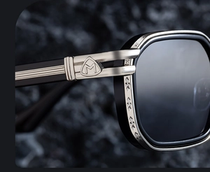 Detail of square polarized sunglasses with silver shield M logo and engraved metal temple