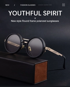 Detail of round frame polarized sunglasses with golden metal hinges on a leather display