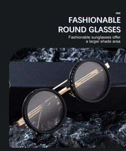 Detail of round steampunk sunglasses with gold metal frame on a dark stone background