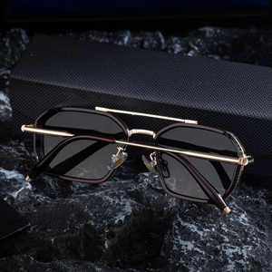 Detailed macro view of square metal sunglasses with tortoise shell texture and gold frame