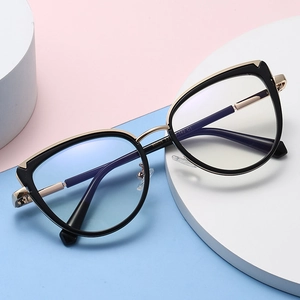 Lunettes de soleil œil-de-chat tendance avec monture noir et or sur fond coloré