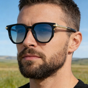 Close-up of men's sunglasses featuring blue gradient lenses and gold temple details