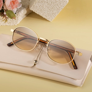 Modern oval gold metal sunglasses with gradient lenses and cream leather folding case