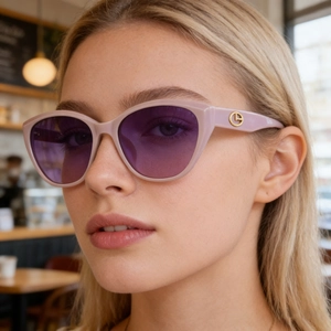 Fashionable nude cat-eye sunglasses with gradient purple lenses and gold logo detail