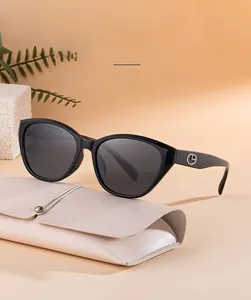 Detail of black cat-eye polarized sunglasses with gold logo and pink leather case