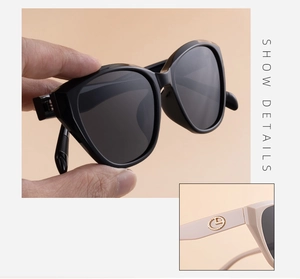 Close-up of beige sunglasses arms featuring a circular gold metal logo insert