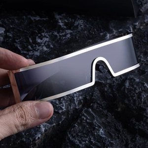 Close-up of cyber-style silver metal frame sunglasses with a sleek one-piece black lens