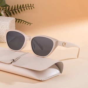 Chic beige cat-eye polarized sunglasses with gold logo and matching leather pouch