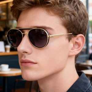 Detail of male model wearing retro oval metal sunglasses with double bridge and gold frame