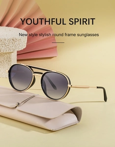 Close-up of gold metal oval sunglasses with gradient lenses and leather pouch