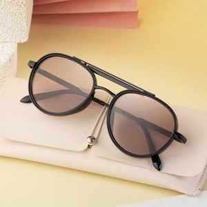 Retro double-bridge metal sunglasses with brown lenses and leather case on warm background