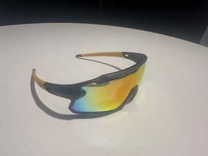 Macro view of black and orange cycling sunglasses with iridescent rainbow coated lenses