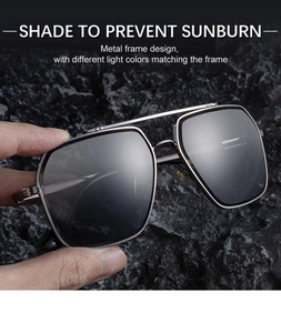 Detail of square silver metal frames and dark grey lenses on black rock background