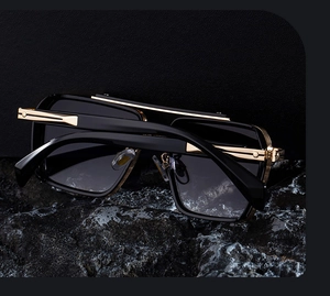 Detail of square black and gold punk sunglasses featuring a metal double bridge design