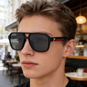 Close-up of square polarized sunglasses with silver metal hinges and red temple detail