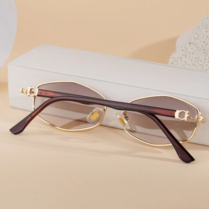Détail macro de lunettes de soleil à monture dorée avec charnière circulaire et verres bruns