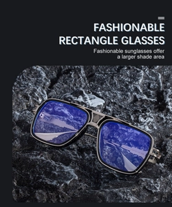 Detail of retro rectangular metal sunglasses with blue lenses on dark volcanic rock