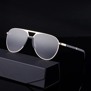 Classic aviator sunglasses with gold metal frame and black case on dark reflective surface