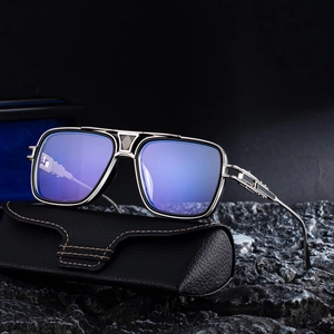 Retro square metal sunglasses with blue lenses and leather case on rock surface