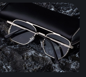 Silver metal aviator sunglasses with dark grey lenses and a black leather texture case