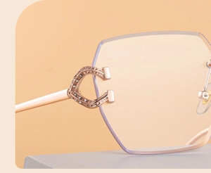 Detail of rose gold C-shape temple hinge with crystal diamonds on rimless sunglasses