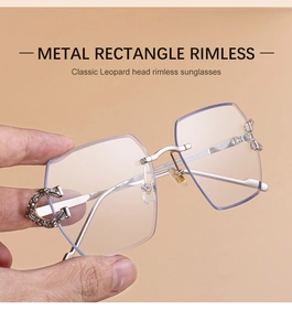Close-up of rimless rectangle sunglasses with silver metal C-shape hinge and diamond accents