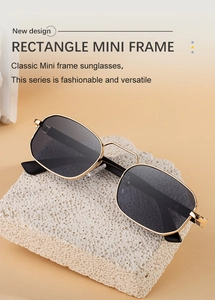 Detail of vintage square metal sunglasses on a textured stone prop with warm background