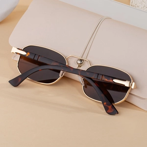 Close-up of retro gold metal sunglasses with tortoise temples and leather case