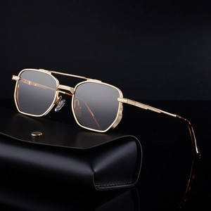 Classic double-bridge gold metal square sunglasses with leather case on black surface