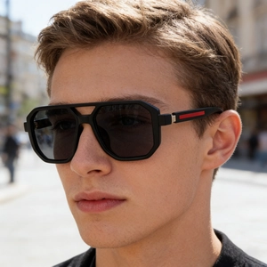 Details einer matt-schwarzen quadratischen Sonnenbrille mit roten Streifen am Bügel