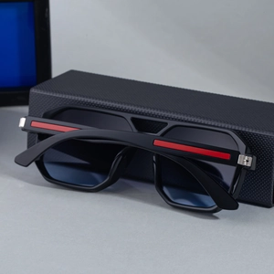 Quadratische Sonnenbrille mit rotem Streifen am Bügel und schwarzem Waben-Brillenetui