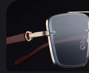 Macro shot of luxury gold C-hinge detail and wood grain temples on square sunglasses