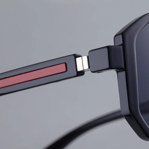 Makroaufnahme der schwarzen Sonnenbrille mit rotem Streifen und Metallscharnier-Detail