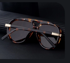 Detail of tortoise pilot sunglasses with dark lenses and gold metal hardware