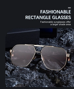Detail einer quadratischen Gold-Sonnenbrille mit Doppelsteg auf schwarzem Steinhintergrund