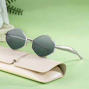 Lunettes de soleil polygonales avec monture en métal argenté et verres foncés sur étui beige