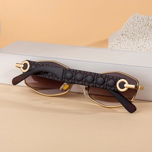 Detail of gold metal eyewear arm featuring geometric cannage pattern and gradient lenses