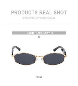 Front detail of hexagonal gold metal sunglasses with dark gray lenses and black temple tips