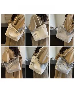 Detailed views of woman wearing pearl-embellished tote bag with bow and heart pendant