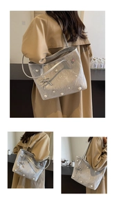 Detail of silver pleated tote bag with pearl rhinestones and bow accent on shoulder strap