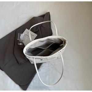 Internal view of a white leather tote bag featuring spacious compartments and pockets