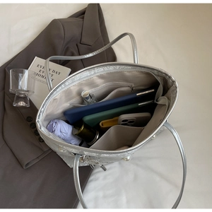 Interior view of silver tote bag showing spacious compartments and pearl details