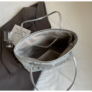 Top view of silver tote bag interior with zipper pocket and pearl bow detail