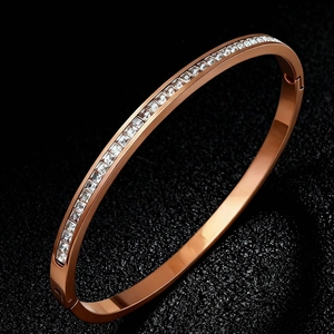 Detail of rose gold titanium steel bangle featuring a row of pavé square-cut zircons