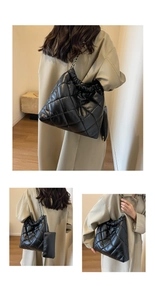 Detail of black quilted puffer bag with chain strap and matching small pouch set