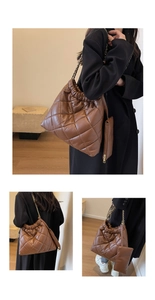 Detail of brown quilted shoulder bag with gold chain strap and mini zipper pouch accessory